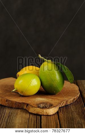 Limes And Lemons On Wooden Board