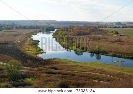 Autumn Fields And Narrow River With Reflections Of Clouds