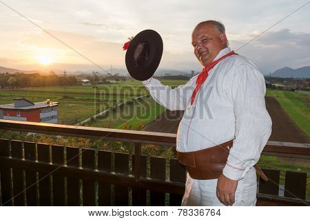 Man Wearing Traditional Clothing Waving His Hat