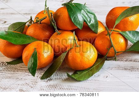 Tangerines With Leaves On A Wooden Table