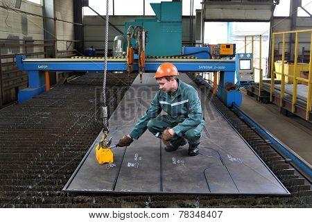 Worker Fixes Magnetic Lifters Lift Plane Of Steel Sheet.