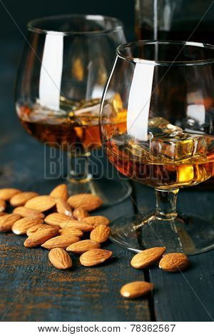 Dessert liqueur Amaretto with almond nuts, on dark wooden table