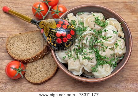Russian Cuisine: Dumplings On A Plate, Cherry Tomatoes And Bread On A Wooden Background.