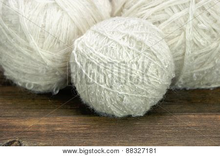 White Wool Rolls On Wood Background