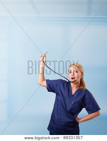 Pretty young nurse in hospital listening to empty copy space with sthetoscope