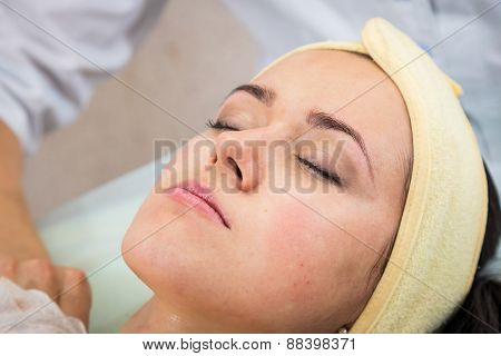Cosmetic injection in the spa salon. Beautician makes injection into the patient's face