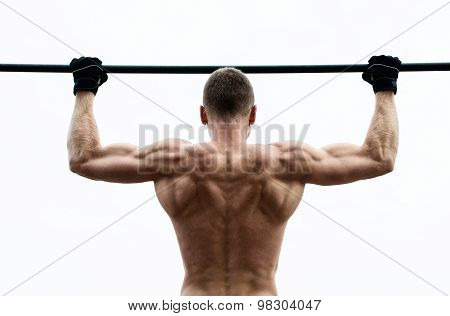 Muscle Man Making Pull-up On Horizontal Bar Against The Sky