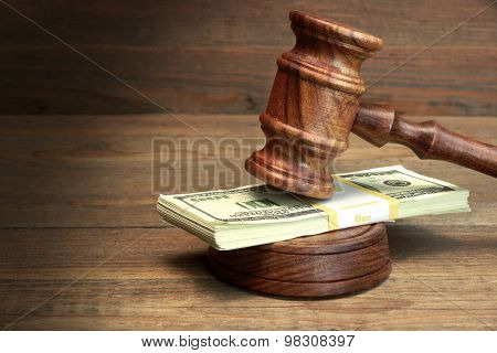Bundle Of Money, Judges Gavel And Soundboard On Wooden Table