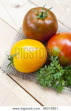 Assorted tomatoes: orange, pink, black tomatoes with parsle
