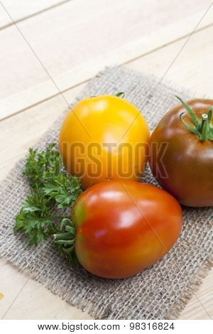 Assorted tomatoes: orange, pink, black tomatoes with parsle