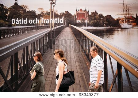 Passers-by on the background of a huge banner with the bridge Sk