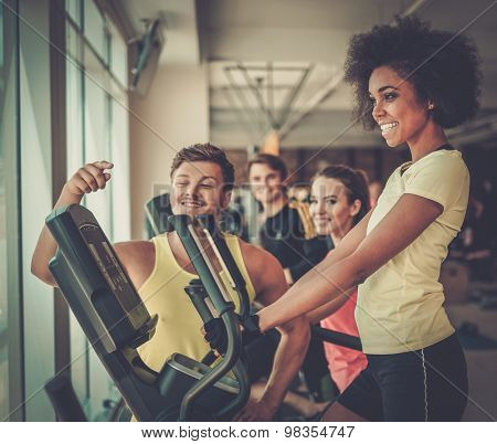 Trainer explaining how to use elliptical training machine 