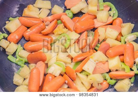 Preparing sausage and vegetables.