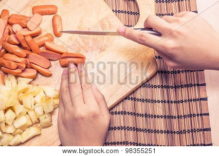 Preparing sausage and vegetables woman hands vintage tone.