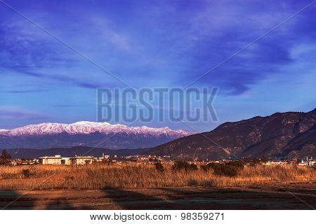 Lake overgrown with reeds mountains in background