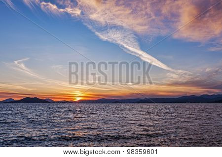 Beautiful Sunset on the sea, in the background mountains