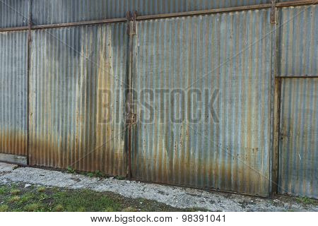 Old Rusty Galvanised Corrugated Iron Building With Large Closed Double Doors Viewed At An Oblique An