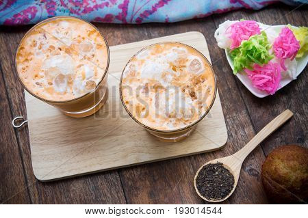 thai tea milkshake beverage thailand style and muffin cupcake dessert on wood table