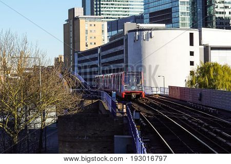 LONDON, ENGLAND - MAY 5, 2017: Canary Wharf, DLR station in London, UK. DLR train leaving the station on a bright day
