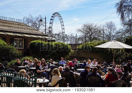 LONDON, ENGLAND, UK - APRIL 24 2017 : unidentified people relax in the park lunch break. Is widespread eating lunch in one of the city parks during the beautiful days