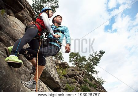 young couple in love climbers. man and woman hanging on a rock on the ropes. climbing, extreme sport