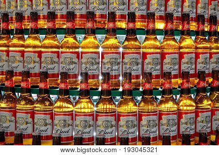 Kiev, Ukraine - January 25, 2013. Close up shot of continuous rows of back-lit beer bottles of Budweiser on the round shelves.