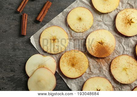 Composition with fresh cut apples and cinnamon prepared for making chips, on grey table