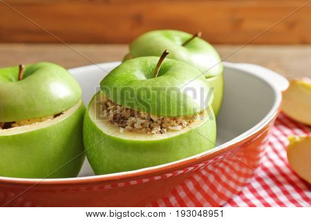 Fresh stuffed apples in baking dish on table, closeup