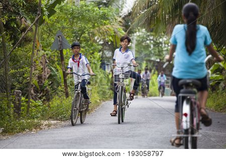 An Binh Island, Vietnam - March 25, 2017 : Vietnamese pioneers go home from school by bicycles on An Binh island, Vinh Long, Vietnam