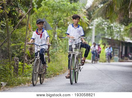 An Binh Island, Vietnam - March 25, 2017 : Vietnamese pioneers go home from school by bicycles on An Binh island, Vinh Long, Vietnam