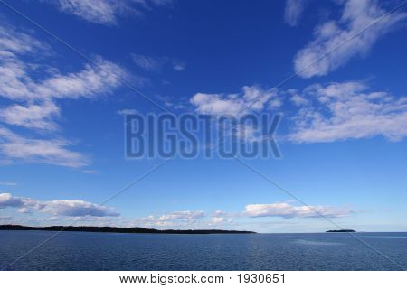 Blue Sky With White Clouds Above Blue Lake