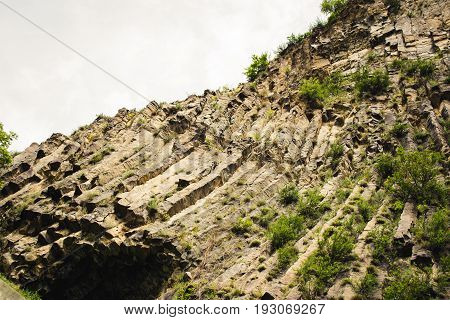 Mountain unique geological formation called Symphony of Stones. Basalt rock. Ecotourism. Nature background. Adventure holiday. Armenia, Garni. Travel vacation. Climbing tourism concept. Copy space
