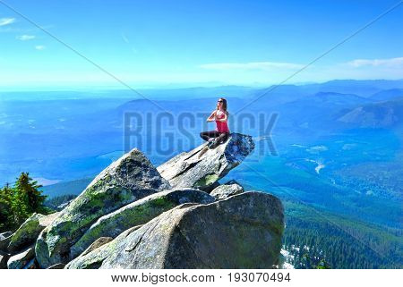 Meditation on rock with mountains and valley views. Mount Pilchuck. Cascade Mountains.  Seattle. Washington. United States.