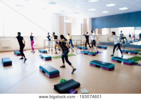 Blurred background of people group of girls playing in yoga and fitness,crossfit in the gym.