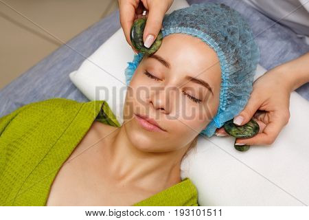 Spa treatment. Facial massage with jade stones. Alternative medicine. Massage of forehead zone. Guasha
