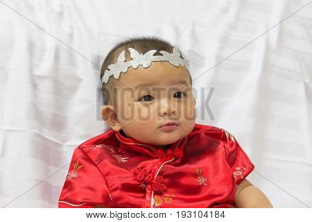 Asian cute new born girl baby with gesture of congratulation happy chinese new yeras.