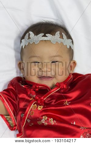 Asian cute new born girl baby with gesture of congratulation happy chinese new yeras.