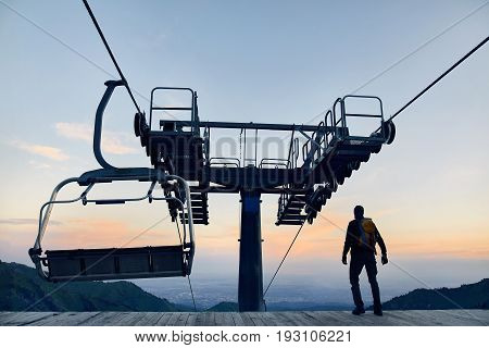 Tourist Near Cable Car In The Mountains