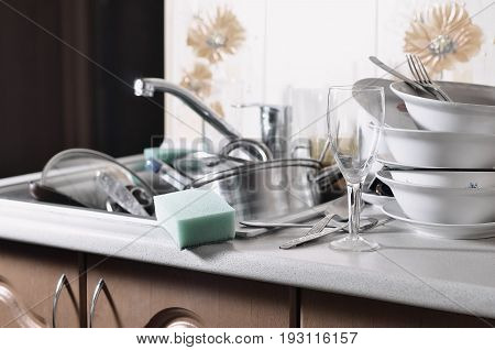 A Huge Pile Of Unwashed Dishes In The Kitchen Sink And On The Countertop