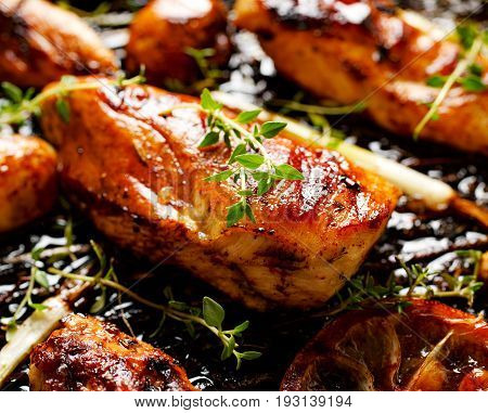 Grilled chicken fillets in the marinade with the addition of  green onion, lemon and aromatic herbs on the grill pan