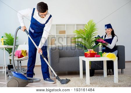 Cleaning service team vaccuuming, dusting and watering plants