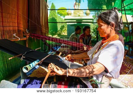 CHIANGMAI THAILAND - JANUARY 24 2015: Indigenous woman is demonstrating weaving fabric in 22nd Traditional Skirt Fabric and The Indigenous Product and Culture Festival in Mae Chaem of Chiangmai Thailand