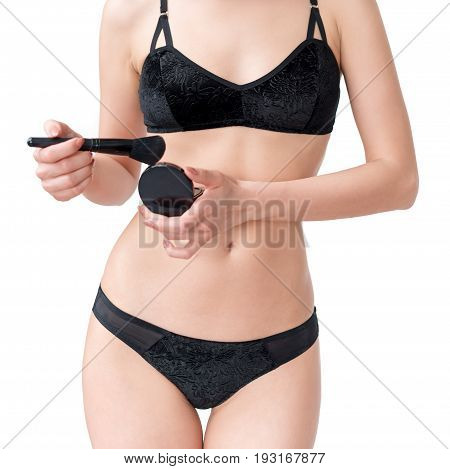 Slim beautiful woman in black lingerie holding makeup brush isolated on white background. Girl applying make up, body parts, noface