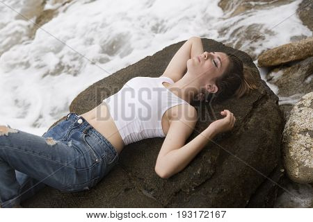 Teenage Girl Lying On The Rocks