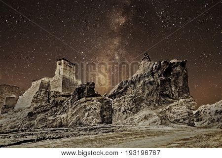 Ruins and Basgo Monastery surrounded with stones and rocks sky with clouds in the background Himalayan Mountain range Leh Ladakh Jammu and Kashmir India - tinted stock image of Indian monasteries