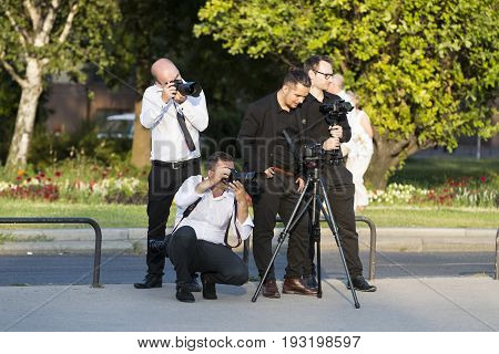 BUDAPEST, HUNGARY. 23 JUNE, 2017: A group of wedding photographers on the streets of Budapest is holding a photo session for a couple of newlyweds.