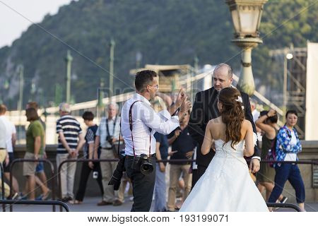BUDAPEST, HUNGARY. 23 JUNE, 2017: A group of wedding photographers on the streets of Budapest is holding a photo session for a couple of newlyweds.