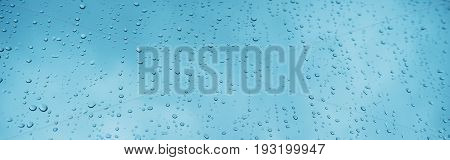 Blue glass with raindrops background texture horizontal top view isolated rain on the window backdrop light blue sky clear water on space blank back mockup nuture wall
