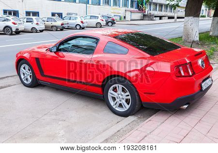 Samara Russia - May 22 2017: Red Ford Mustang parked up at the city street in summer day. The Ford Mustang is an American automobile manufactured by Ford