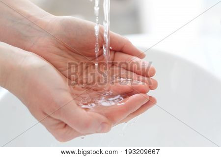 Woman wash her hands under water. Wash your hand.